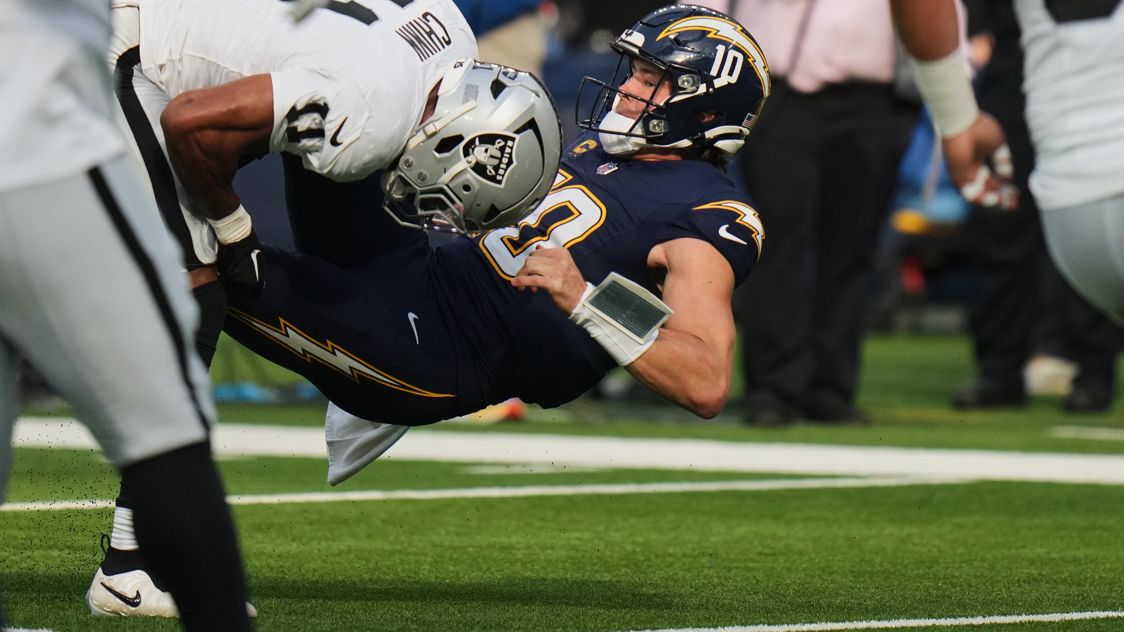 Las Vegas Raiders safety Jeremy Chinn (11) tackles Los Angeles Chargers quarterback Justin Herbert (10) during the first half of an NFL football game, Sunday, Nov. 30, 2025, in Inglewood, Calif. (AP Photo/Jae C. Hong)