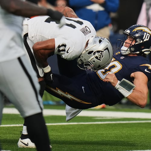 Las Vegas Raiders safety Jeremy Chinn (11) tackles Los Angeles Chargers quarterback Justin Herbert (10) during the first half of an NFL football game, Sunday, Nov. 30, 2025, in Inglewood, Calif. (AP Photo/Jae C. Hong)