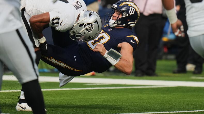 Las Vegas Raiders safety Jeremy Chinn (11) tackles Los Angeles Chargers quarterback Justin Herbert (10) during the first half of an NFL football game, Sunday, Nov. 30, 2025, in Inglewood, Calif. (AP Photo/Jae C. Hong)