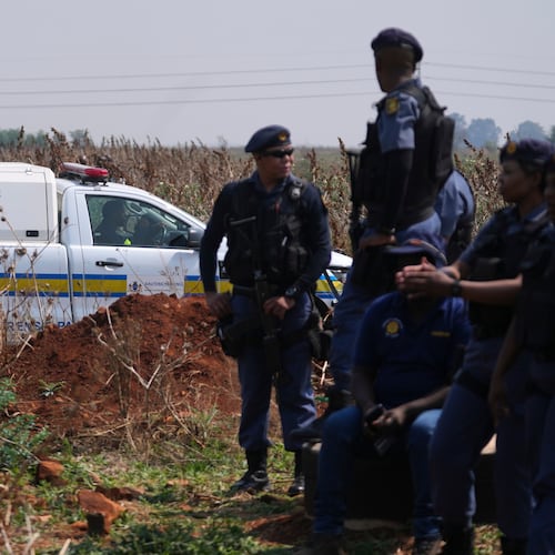 Forensic investigators work at the site where the body of a woman was discovered on the outskirts of Johannesburg, South Africa, Thursday, Sept. 17, 2026. (AP Photo/Themba Hadebe)