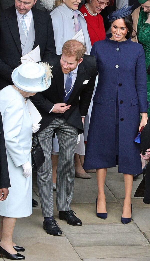 Prince Harry, accompanied by wife Meghan Markle, talks to his grandmother, Queen Elizabeth II, at the wedding of his cousin, Princess Eugenie.