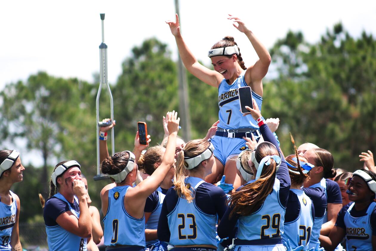 Warner University quarterback Kathryn Hutchinson (top), a River Ridge High grad, celebrates with teammates after the Royals won the Sun Conference Tournament championship Saturday, April 25, 2026, in Lake Wales, Florida. Hutchinson was named tournament MVP after the 25-14 win over Keyser University. (Courtesy of Reese Mole/Warner University)