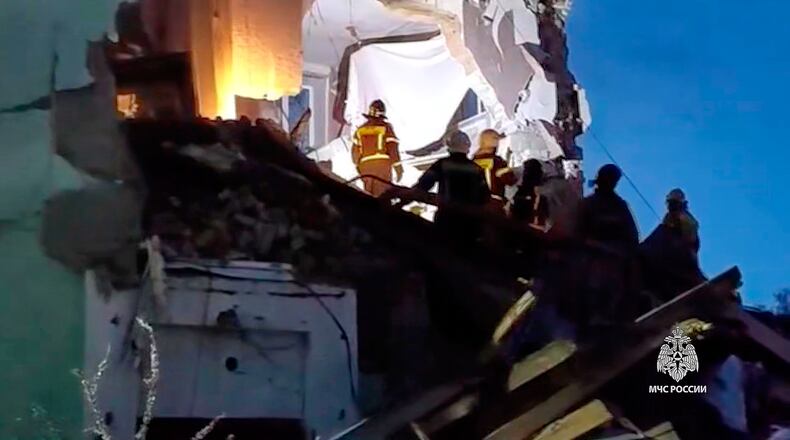 In this photo provided by the Russian Emergency Ministry Press Service, Russian Emergency Ministry employees work at the side of the damaged multi-storey apartment building hit by a Ukrainian drone in Syzran in Russia's Samara Region Wednesday, April 22, 2026. (Russian Emergency Ministry Press Service via AP)
