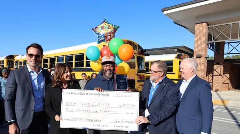 Gwinnett County Public Schools bus driver Omar Zachery (center) was honored with the Rotary Club of Gwinnett’s Hidden Hero Award for demonstrating the Rotary motto of “Service Above Self” in his work. (Courtesy of Gwinnett County Public Schools)