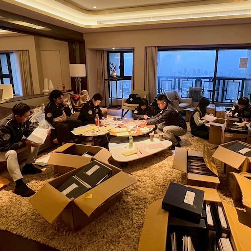 In this photo released by Ministry of Justice Investigation Bureau, Investigation Bureau agents check documents after they seized an apartment which belongs to the suspected head of a criminal scamming syndicate, in Taipei, Taiwan, Tuesday, Nov. 4, 2025. (Ministry of Justice Investigation Bureau via AP)