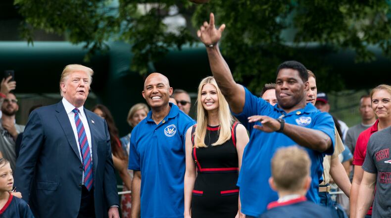 President Donald Trump watches Herschel Walker, the retired football star, throw a pass at the White House Sports and Fitness Day, in Washington, May 30, 2018. Standing with Trump are Mariano Rivera, the retired New York Yankees closer; and Ivanka Trump. (Doug Mills/The New York Times)