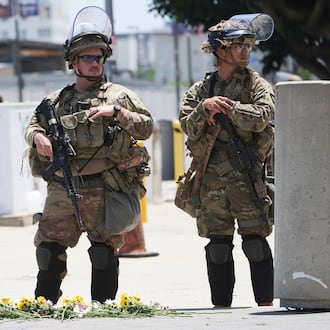 FILE - Members of the California National Guard and U.S. Marines guard a federal building on Tuesday, June 17, 2025, in Los Angeles. (AP Photo/Damian Dovarganes, File)