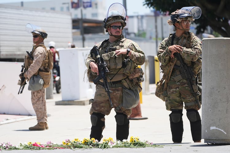 FILE - Members of the California National Guard and U.S. Marines guard a federal building on Tuesday, June 17, 2025, in Los Angeles. (AP Photo/Damian Dovarganes, File)