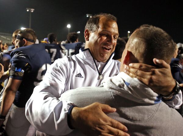 In this file photo, then-Norcross coach Keith Maloof, facing, celebrates with assistant coach Pat Standard following a 41-27 win over Colquitt County in their Class 6A semifinal in Norcross, Ga., Dec. 7, 2012. (Jason Getz/AJC)