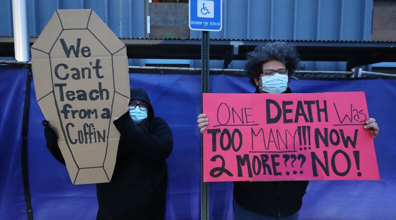 012121 Marietta: High school teacher Elizabeth Alentyeu and her husband Raul Candia are among hundreds of Cobb County teachers and staff hold a protest in the parking lot during the school board meeting at the Cobb County School District's Offices on Thursday, Jan. 21, 2021, in Marietta. Cobb teachers are pressing the district for improved COVID-19 response.  Curtis Compton / Curtis.Compton@ajc.com”