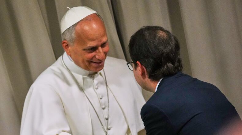 Pope Leo XIV, left, greets Anthropic co-founder Christopher Olah during the presentation of the Pope's first encyclical, "Magnifica humanitas: On Safeguarding the Human Person in the Time of Artificial Intelligence," at the Vatican, Monday, May 25, 2026. (AP Photo/Alessandra Tarantino)