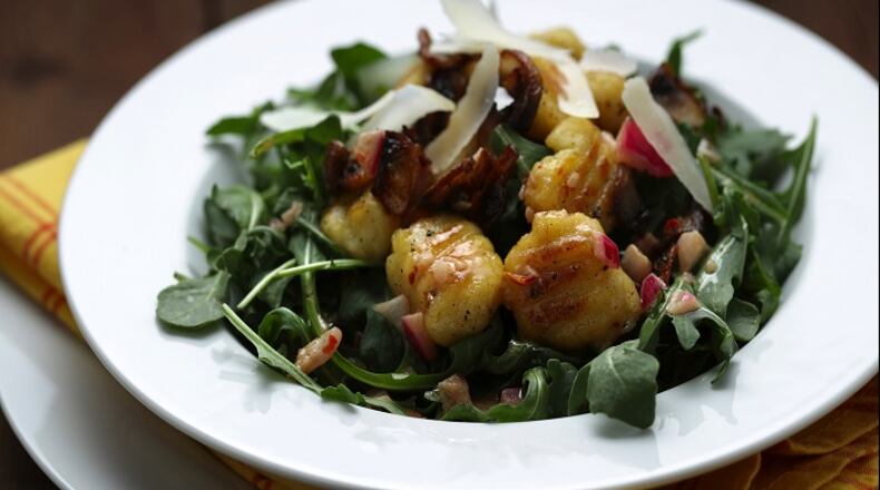 Potato gnocchi are browned in a skillet after boiling, then tossed with a simple vinaigrette and garnished with arugula, sauteed mushrooms and shaved Parmesan. (Mark Graham/food styling) (E. Jason Wambsgans/Chicago Tribune/TNS)