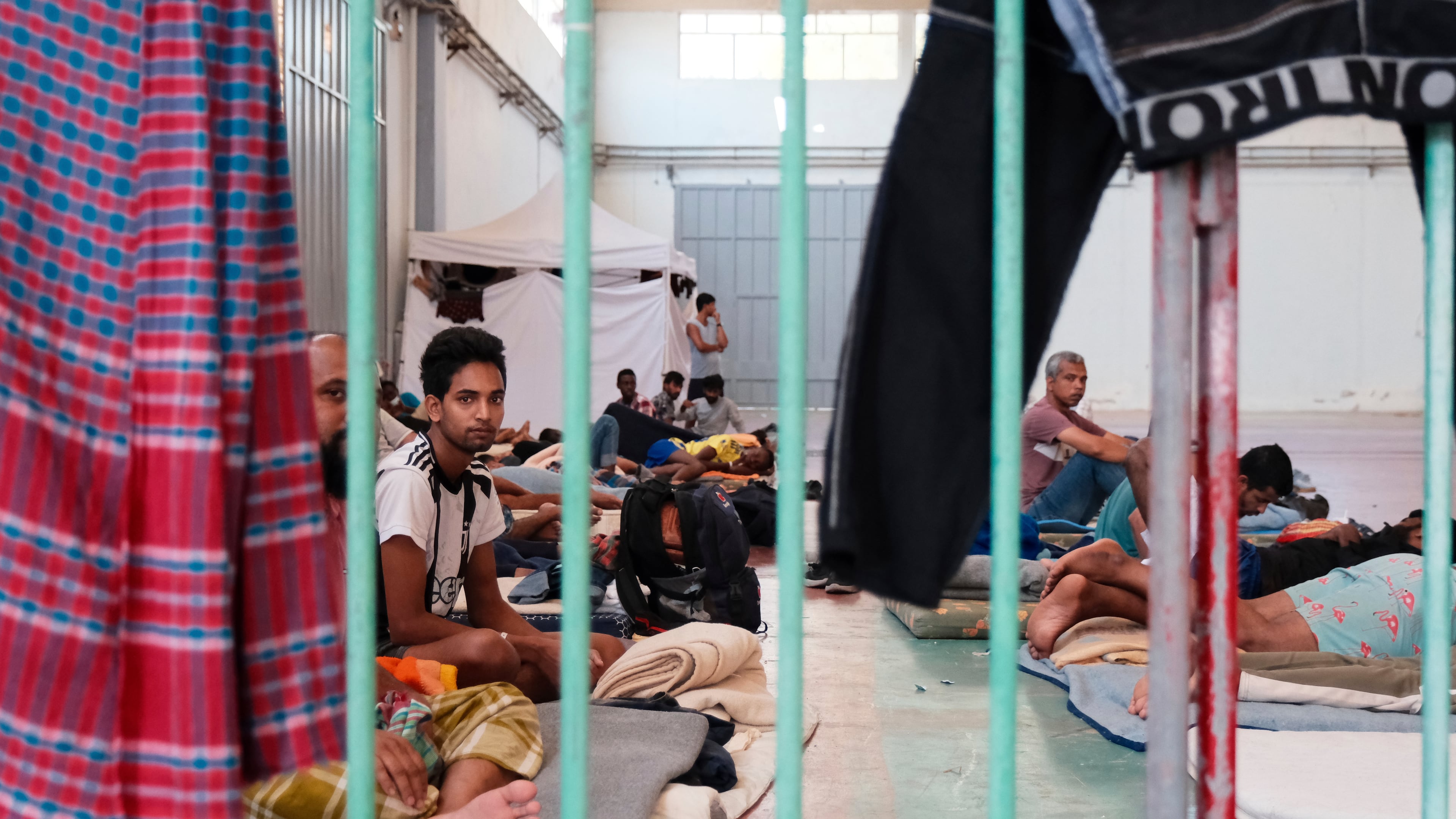 Migrants who arrived recently at the island of Crete, despite a suspension of asylum claims and plans for tougher detention rules, are being held under guard at a temporary shelter in the village of Agia, near Chania city, on the island of Crete, southern Greece, Tuesday, Aug. 19, 2025. (AP Photo/Giannis Angelakis)