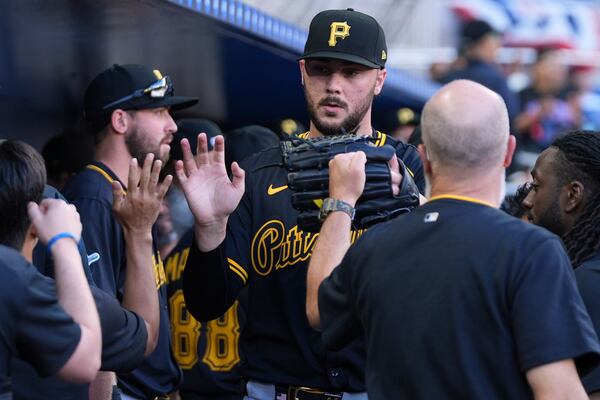 Pittsburgh Pirates pitcher Paul Skenes is high-fived in the dugout after being relieved during the sixth inning of an opening-day baseball game against the Miami Marlins, Thursday, March 27, 2025, in Miami. (AP Photo/Lynne Sladky)