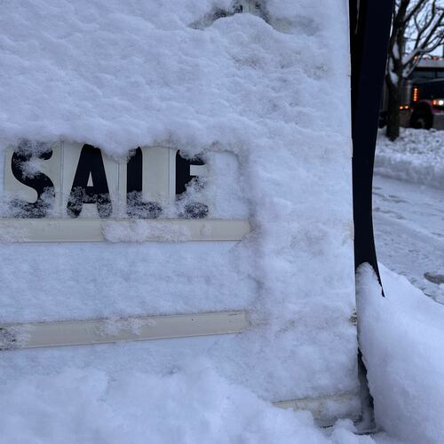 A store's promotional sign is snowed under in Lowville, N.Y., on Friday, Nov. 28, 2025. (AP Photo/Cara Anna)