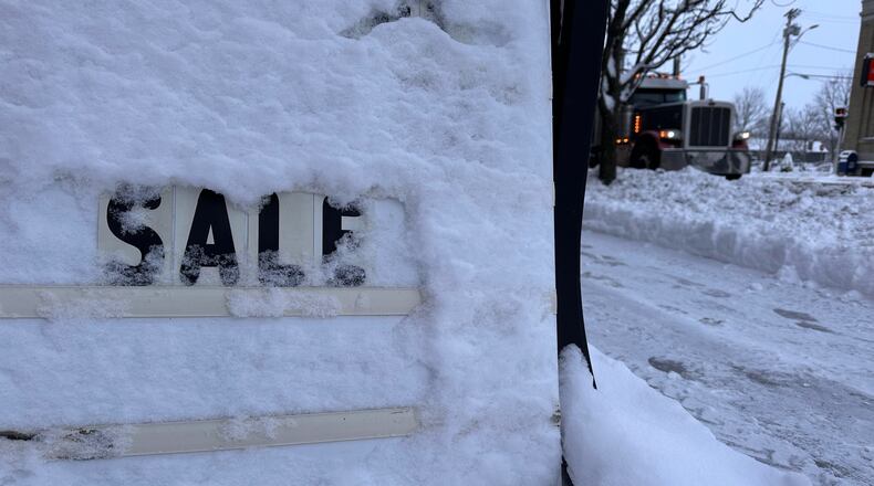 A store's promotional sign is snowed under in Lowville, N.Y., on Friday, Nov. 28, 2025. (AP Photo/Cara Anna)