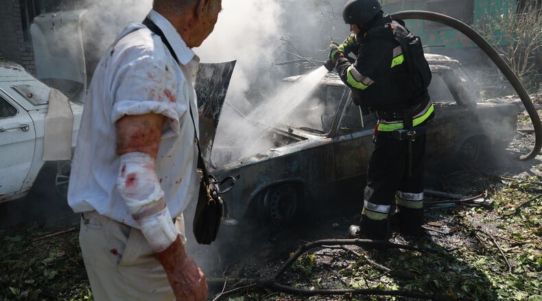 Rescue workers try to put out a fire of a residential building and cars burning after a Russian air guided bomb strike in Zaporizhzhia, Ukraine, Monday, Aug. 10, 2026. (AP Photo/Kateryna Klochko)