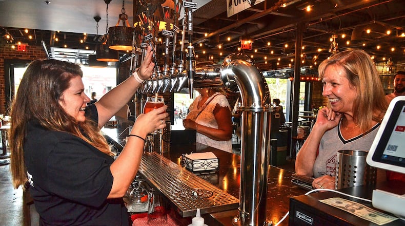 Bartender Lauren Kell shares a laugh with a customer during happy hour at Glover Park Brewery. CONTRIBUTED BY CHRIS HUNT PHOTOGRAPHY