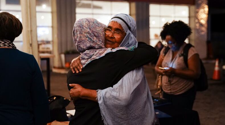 Amina Osman, right, a Clarkston resident and refugee from Somalia, hugs a woman at Refuge Coffee in Clarkston during an event in October. (Elijah Nouvelage for The Atlanta Journal-Constitution)