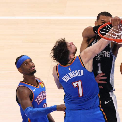 San Antonio Spurs forward Victor Wembanyama (1) dunks while being fouled by Oklahoma City Thunder center Chet Holmgren (7) during the second overtime of Game 1 in a third-round NBA basketball playoffs series Monday, May 18, 2026, in Oklahoma City. (AP Photo/Nate Billings)