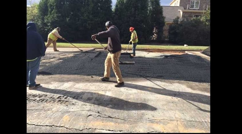 Workers patch a sinkhole in Johns Creek on Friday.