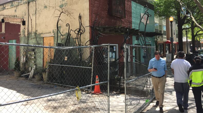 Pedestrians in downtown Decatur pass by Java Monkey, which closed in November due to a fire. The part of the property behind the fence used to feature the coffee shop’s wine bar and outdoor patio. That half of the business has since been torn down.