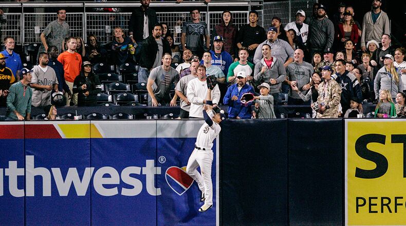 San Diego Padres outfielder Jon Jay jumps at the wall as the ball hit by Braves' Freddie Freeman bounces back to the field in the ninth inning at PETCO Park June 7, 2016, in San Diego.