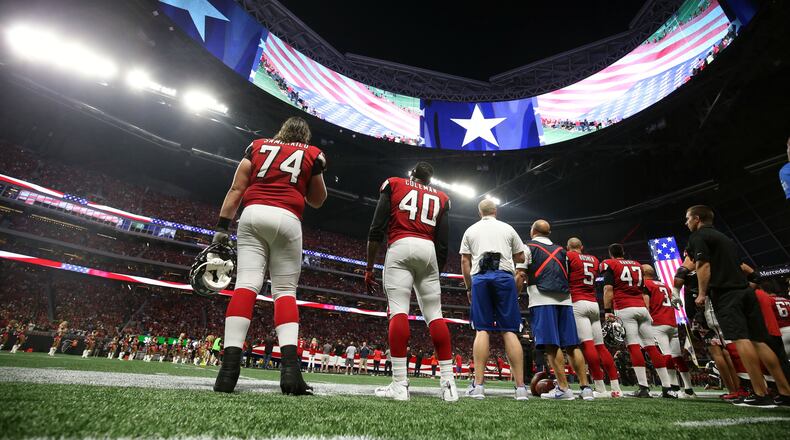 Atlanta Falcons offensive tackle Ty Sambrailo (74), fullback Derrick Coleman (40) and teammates stand during the national anthem before their game against the Green Bay Packers at Mercedes-Benz Stadium.