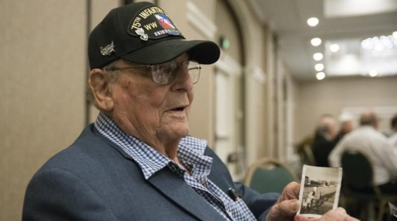 World War II veteran Stan Saltz, 92, holds a photo of himself and a dog named Santa, which he found during the Battle of the Bulge in December 1944.
