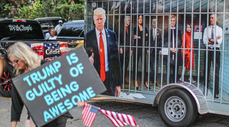 August 24, 2023 Atlanta: Jennifer Vliet (left) brought her message along Rice Street as a wrapped vehicle drove by showing famous democrats in jail late Thursday morning, Aug. 24, 2023 where there were more than 100 protestors gathered outside the jail, and they were prepared to wait for hours until the anticipated arrival of former President Donald Trump this afternoon. The bond agreements for defendants in the Fulton County Trump case so far have ranged from $10,000 for two defendants to the $200K set for Donald Trump. Here are the amounts reported so far (and a list of defendants that don’t have reported bond agreements): Donald Trump: $200,000, Rudy Giuliani: $150,000, John Eastman: $100,000, Kenneth Chesebro: $100,000, Jenna Ellis: $100,000, Sidney Powell: $100,000, David Shafer: $75,000, Stephen Lee: $75,000, Cathleen Latham: $75,000, Ray Smith: $50,000, Robert Cheeley: $50,000, Michael Roman: $50,000, Shawn Still: $10,000 (signature bond), Scott Hall: $10,000, Misty Hampton: $10,000 (signature bond). Defendants who don’t have reported bond agreements: Mark Meadows, Jeffrey Clark, Harrison Floyd, Trevian Kutti. (John Spink / John.Spink@ajc.com)