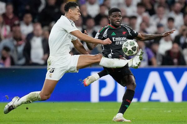 Real Madrid's Jude Bellingham, left, duels for the ball with Arsenal's Thomas Partey during the Champions League quarterfinals second leg soccer match between Real Madrid and Arsenal at the Santiago Bernabeu stadium in Madrid, Wednesday, April 16, 2025. (AP Photo/Bernat Armangue)