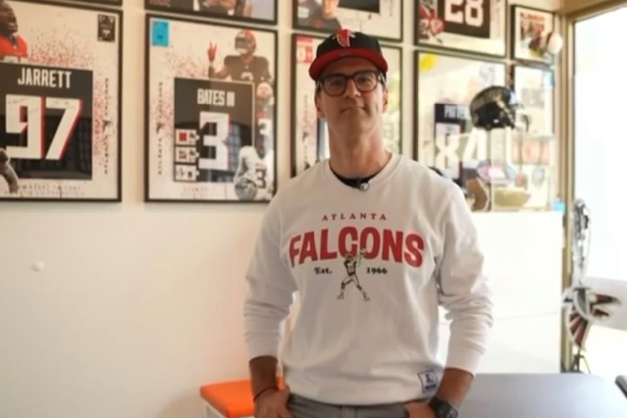 Alexandros Swoch, a German super fan of the Atlanta Falcons, stands in front of his jersey collection at his office in Berlin. Swoch, who is known as Alesantoz by his large following, became a fan of the Falcons back in the 1990s. (Courtesy of Alesantoz)