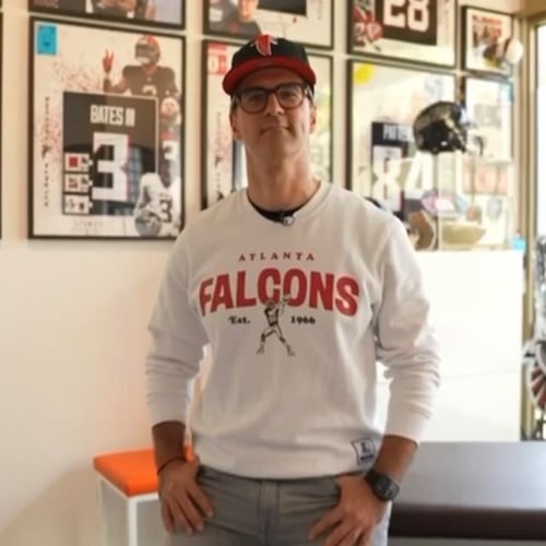 Alexandros Swoch, a German super fan of the Atlanta Falcons, stands in front of his jersey collection at his office in Berlin. Swoch, who is known as Alesantoz by his large following, became a fan of the Falcons back in the 1990s. (Courtesy of Alesantoz)
