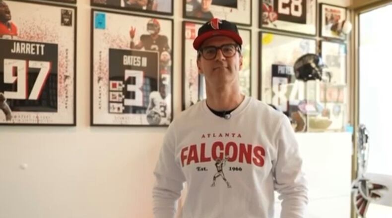 Alexandros Swoch, a German super fan of the Atlanta Falcons, stands in front of his jersey collection at his office in Berlin. Swoch, who is known as Alesantoz by his large following, became a fan of the Falcons back in the 1990s. (Courtesy of Alesantoz)