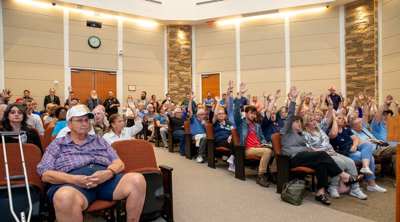 Attendees participate in an unofficial poll at the Board of Commissioners meeting to see who supports maintaining a bipartisan Board of Elections, showing the divide in the crowded board room on Tuesday, June 4, 2024, in Canton, Georgia. The commission maintained a bipartisan elections board, but Democrats have doubts about the new appointee. (Jenni Girtman for The Atlanta Journal-Constitution)