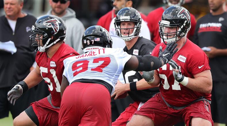 072816 FLOWERY BRANCH: Falcons Andy Levitre (right) and Alex Mack blocks for quarterback Matt Ryan while Grady Jarrett defends during the first day of training camp on Thursday, July 28, 2016, in Flowery Branch. Curtis Compton /ccompton@ajc.com