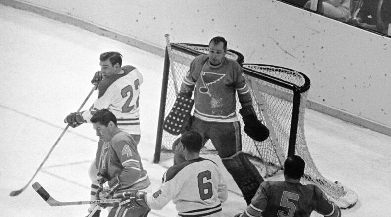 FILE - St. Louis Blues goalie Glenn Hall, top right, is pinned to his net waiting to make a save on a Montreal Canadians shot as Blues' Noel Picard (4) tries to block the puck while Canadiens' John Ferguson (22) and Ralph Backstorm wait for a rebound in the third period of their NHL hockey Stanley Cup game, May 5, 1968. (AP Photo/Fred Waters, File)