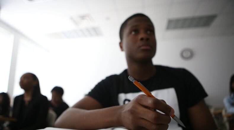 April 17, 2017, Atlanta, Georgia - Pierre Agudze, a student at Clark Atlanta University, takes notes during his calculus class at school in Atlanta, Georgia, on April 17, 2017. Clark Atlanta has the highest student debt in the state at around $40,000 and recently started a program called Finish in Four, which encourages students to take more credits in order to graduate on time and with less debt. (HENRY TAYLOR / HENRY.TAYLOR@AJC.COM)