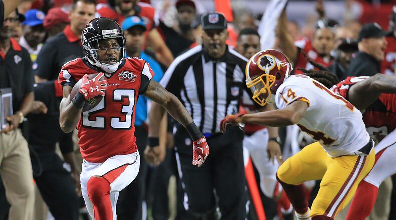 Falcons cornerback Robert Alford intercepts Redskins quarterback Kirk Cousins and breaks away from wide receiver Ryan Grant during sudden death and returns it for the game winning touchdown and a final score of 25-19 in their football game on Sunday, Oct. 11, 2015, in Atlanta. The Falcons remain perfect at 5-0 with the victory. Curtis Compton / ccompton@ajc.com