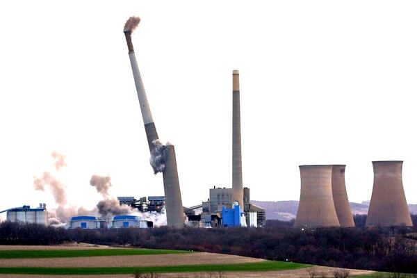 The smokestacks and cooling towers of the former coal-fired Homer City Generating Station crumble in a planned demolition to make way for a new natural gas-fired power plant in Homer City, Pa., Saturday, March 22, 2025. (AP Photo/Gene J. Puskar)