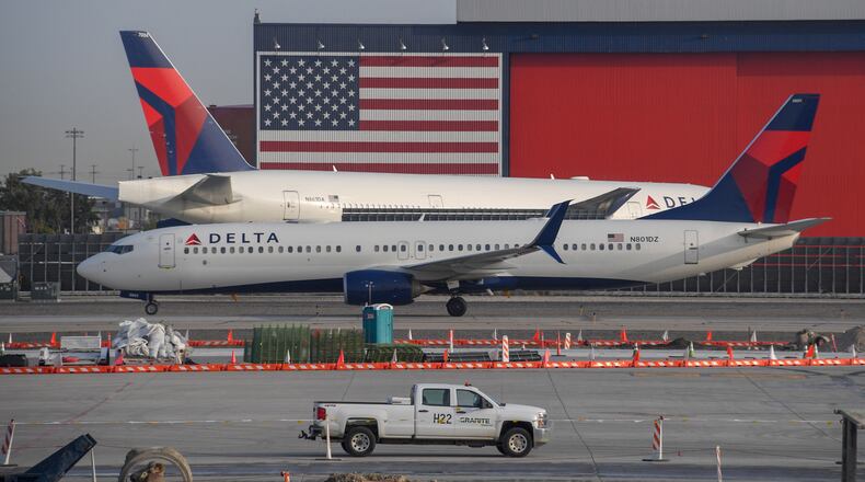 A Delta Airlines Boeing 737, front, passes another Delta Airlines Boeing 777 on the tarmac at Salt Lake City International Airport, Sept. 16, 2020. (Robyn Beck/AFP/Getty Images/TNS)