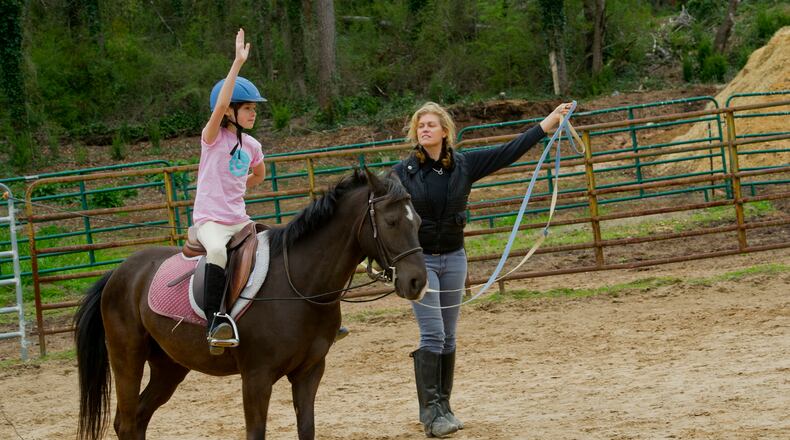 Minnie Black (left) rides a horse as she takes a lesson with instructor Tamara Dillard with Atlanta In-Town Riding Academy at Little Creek Horse Farm on April 3, 2013.  Jonathan Phillips Special