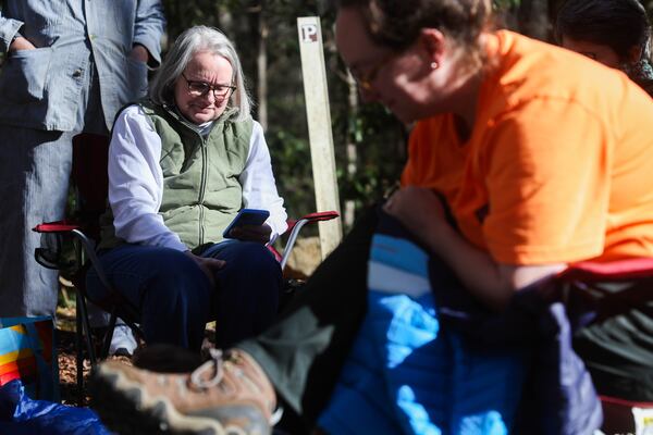 Beth Hosch tries to get service on her phone on Blood Mountain at Byron Reece Memorial Trail in Blairsville on Saturday as the search for her husband, Charles Hosch, continues with volunteers. (Abbey Cutrer/AJC)