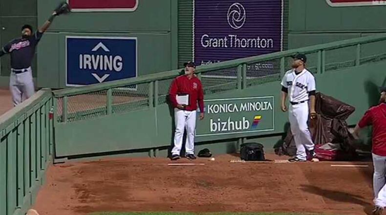 Austin Jackson (left) goes up for the catch while players and coaches in the Red Sox bullpen watch the action.