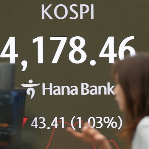 A dealer talks near the screens showing the Korea Composite Stock Price Index (KOSPI) at a dealing room of Hana Bank in Seoul, South Korea, Tuesday, Nov. 4, 2025. (AP Photo/Lee Jin-man)