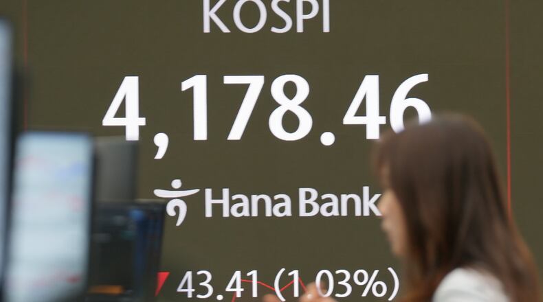 A dealer talks near the screens showing the Korea Composite Stock Price Index (KOSPI) at a dealing room of Hana Bank in Seoul, South Korea, Tuesday, Nov. 4, 2025. (AP Photo/Lee Jin-man)