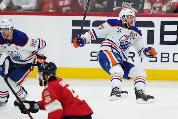 Edmonton Oilers' Connor McDavid (97) falls after a check from Florida Panthers' Aaron Ekblad (5) during the second period in Game 3 of the NHL hockey Stanley Cup finals in Sunrise, Fla., Monday, June 9, 2025. (Nathan Denette/The Canadian Press via AP)