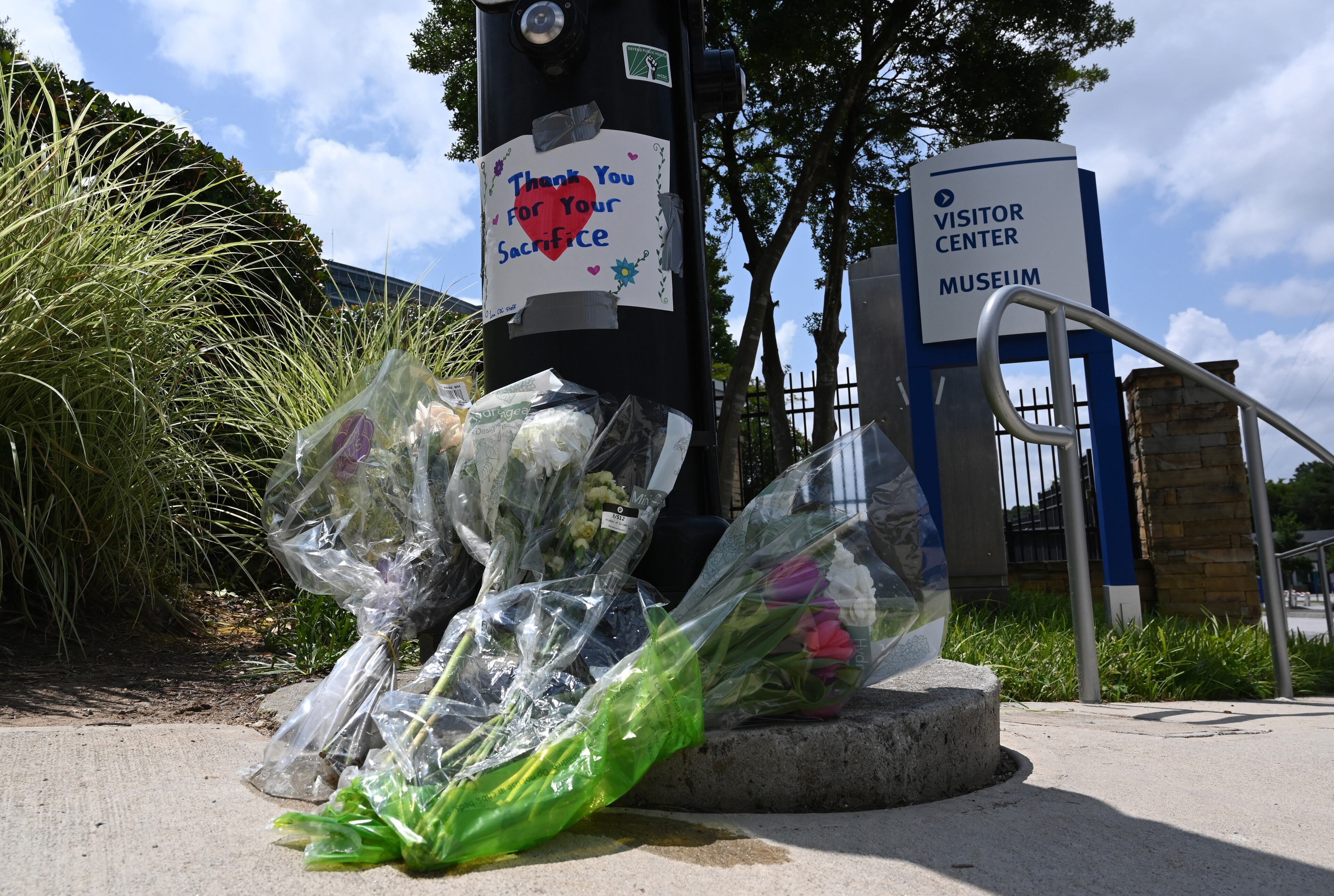 Flowers are left outside the headquarters of the Centers for Disease Control and Prevention on Saturday, Aug. 9, 2025, after a deadly shooting Friday in Atlanta. (Hyosub Shin/AJC)