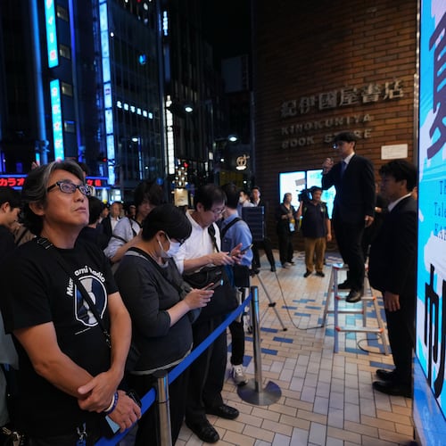 People attend a countdown event to receive copies they pre-purchased, of Haruki Murakami's new book, titled "The Tale of KAHO" after the clock strikes midnight, at a Kinokuniya bookstore in Tokyo on Thursday, July 2, 2026. (AP Photo/Hiro Komae)