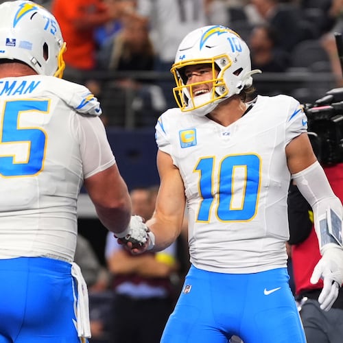 Los Angeles Chargers quarterback Justin Herbert (10) celebrates his touchdown with center Bradley Bozeman (75) during the first half of an NFL football game against the Dallas Cowboys, Sunday, Dec. 21, 2025, in Arlington, Texas. (AP Photo/Tony Gutierrez)